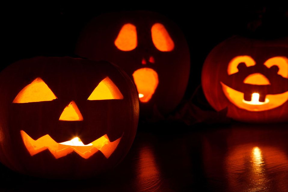 Three carved jack-o'-lanterns lit from inside