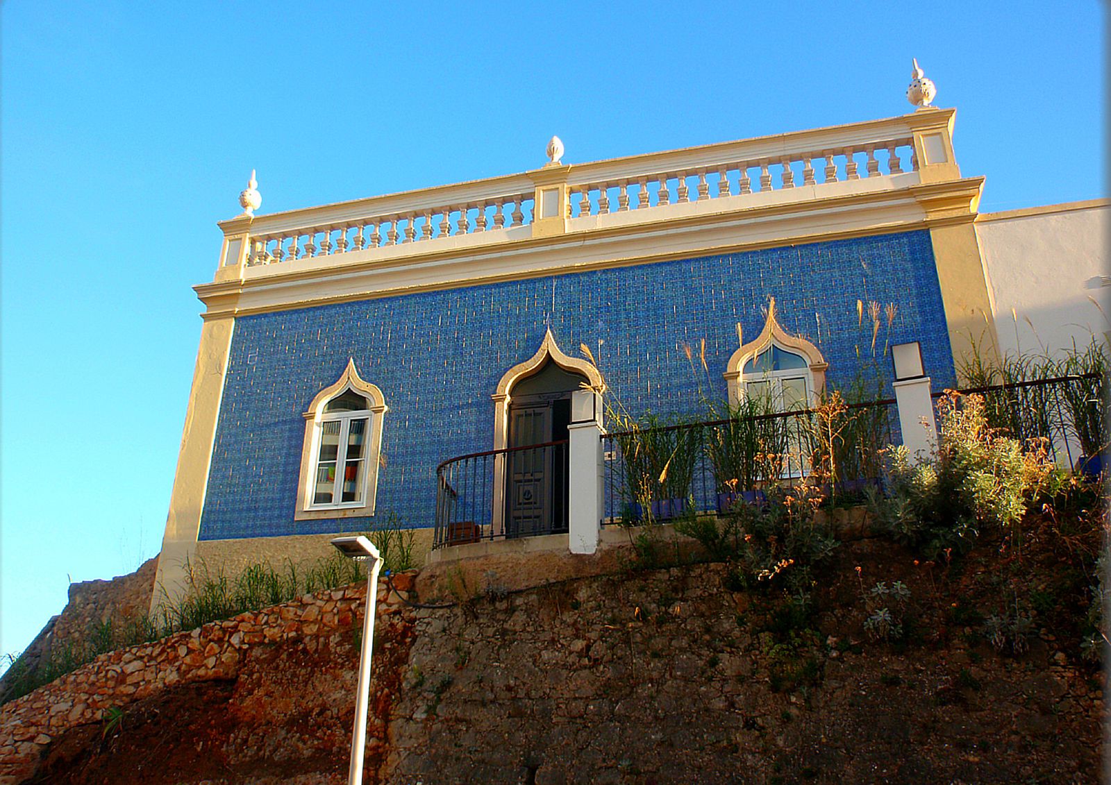 Blue-tiled house with ornate arched windows in Praia da Rocha, Portimão