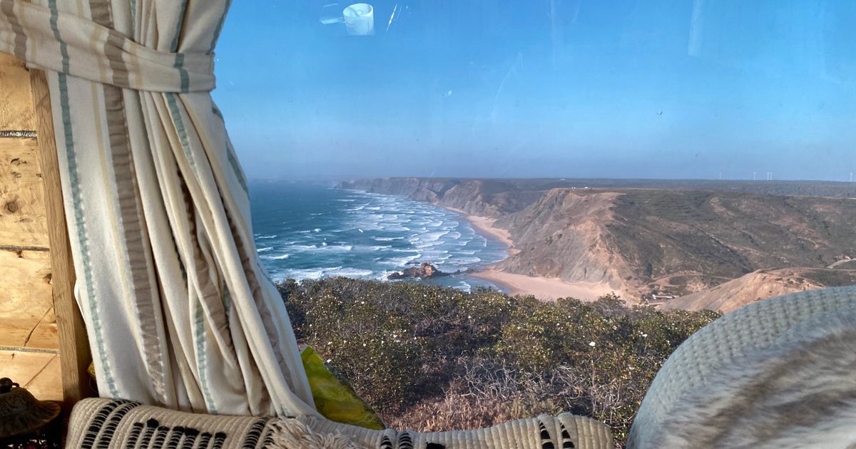 View from a camper van window over the beach and cliffs near Vila do Bispo on the Algarve west coast
